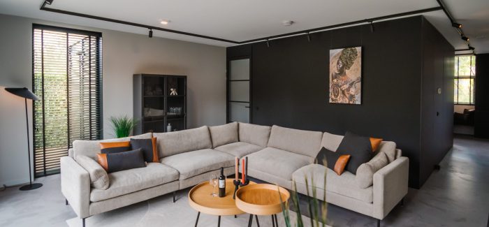 COURAGE interieur, strakke zwart en witte afwerking van wanden en vloeren. Warme meubels en decoratie.